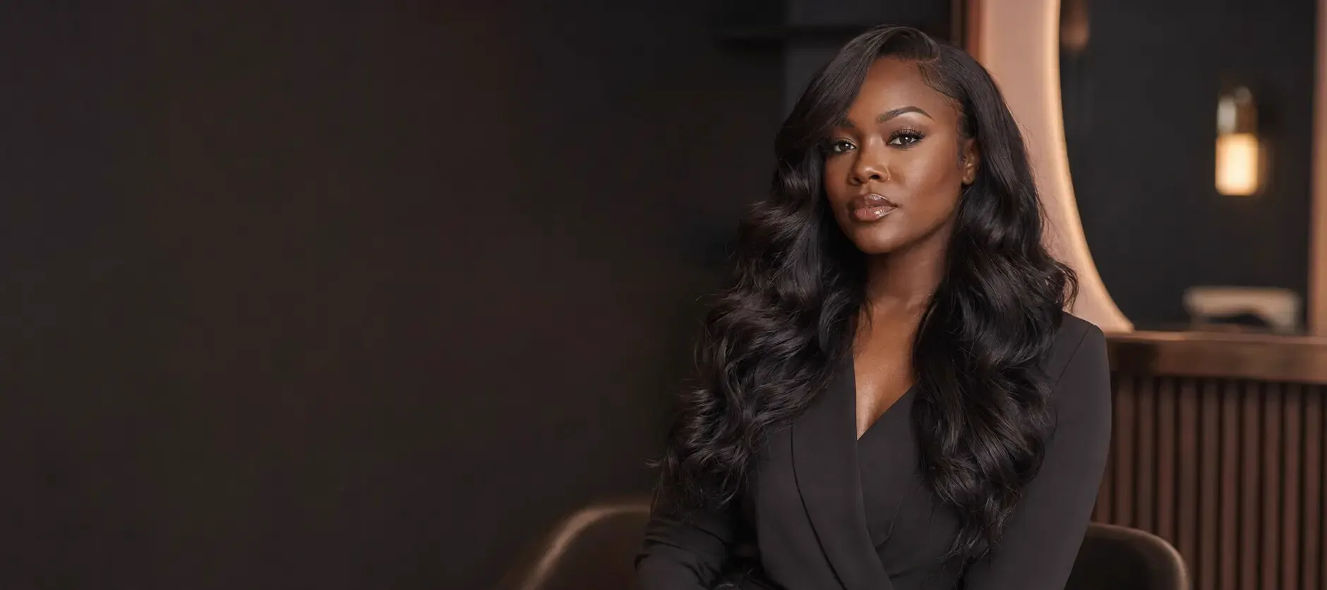 Woman with long glossy waves in an elegant charcoal salon